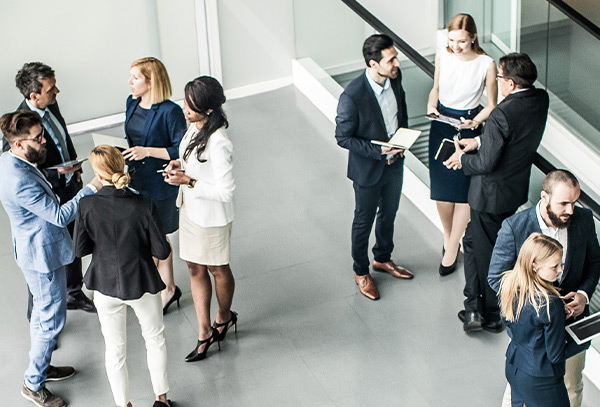 Small groups of men and women converse with one another.