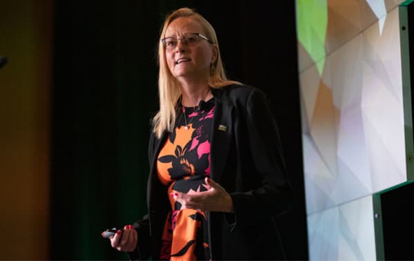 Woman presenting on stage at a conference